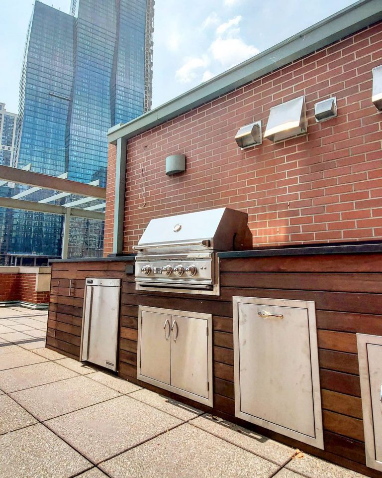 outdoor wooden kitchen with metal details on rooftop deck