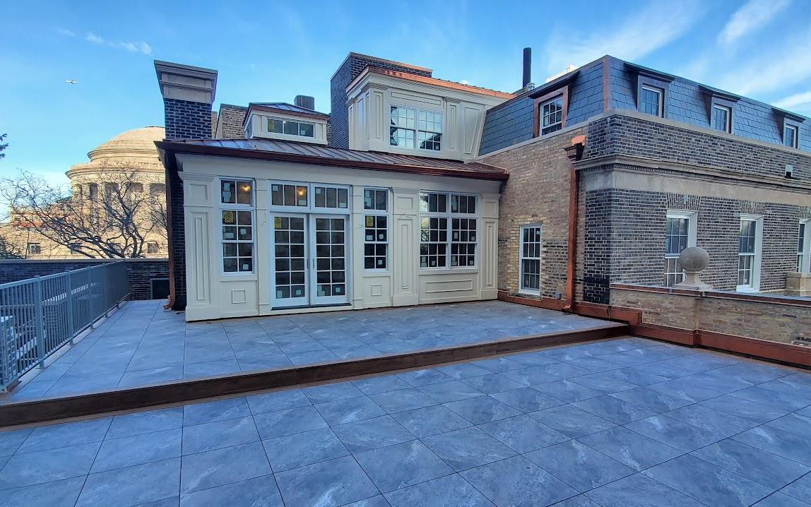 a rooftop deck on the traditional brick building with copper accents