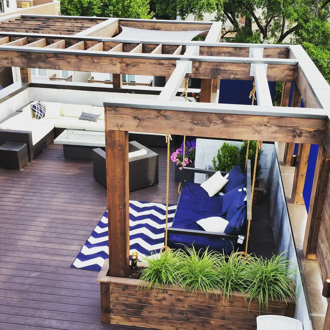 modern roof deck with dark wood pergola, sitting area and a swing
