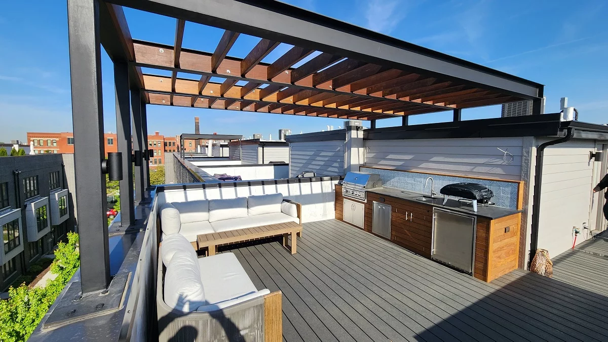 outdoor roof deck with metal pergola, sitting area and wooden kitchen
